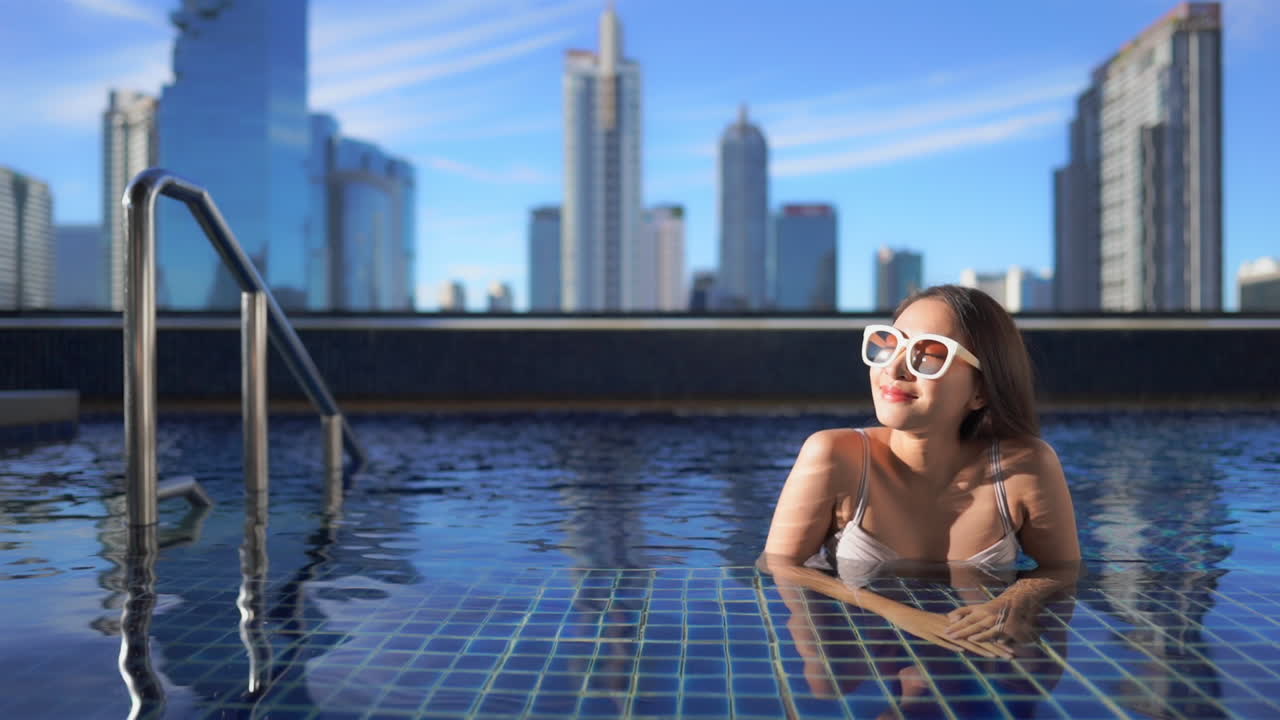 modelo asiático sexy feliz relajándose en la piscina en bangkok