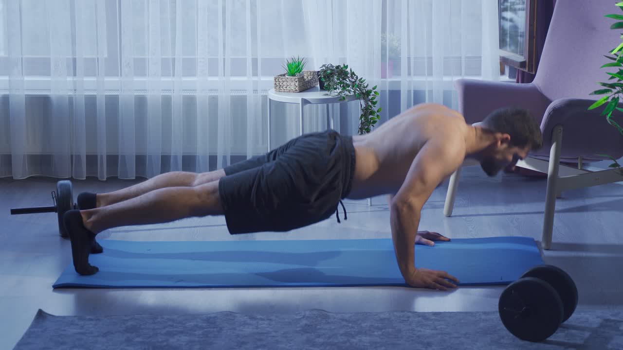 un joven en forma y musculoso que hace ejercicio en casa y no se rinde.