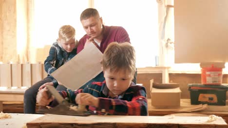 father and sons learning woodworking together