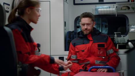 médicos paramédicos discutiendo el trabajo en el coche de ambulancia