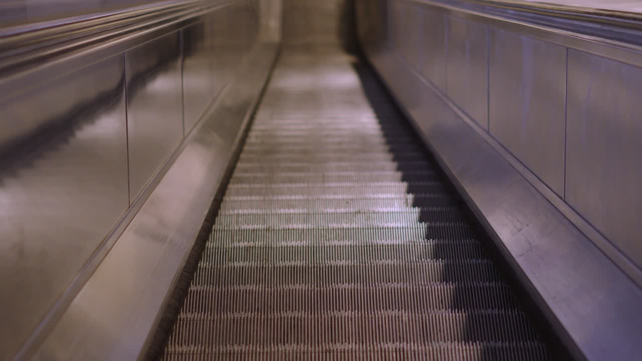 Slow Motion Escalator Moving Staircase Belt of Steps Driven by a Motor Heading Upwards Slowly in Tube Station in London. Electric Stairs Used for Quick Ascent and Movement Between Floors
