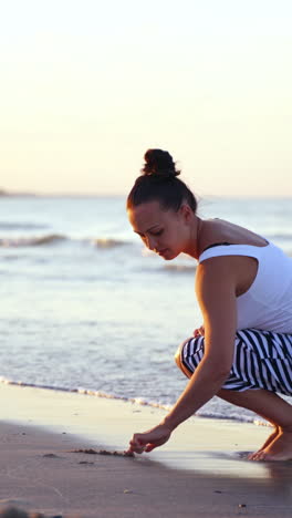 woman in relaxation on beach. shot of beautiful young woman on beach drawing on the sand