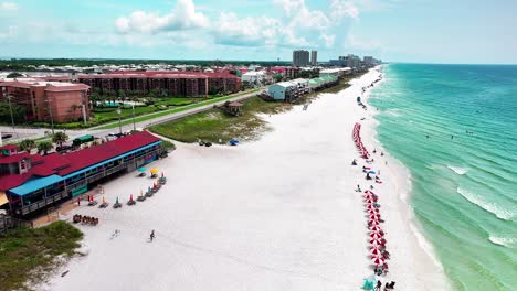 Luftdrohnenaufnahme-Von-Pompano-Joe&#39;s-Restaurant-Und-Parkplatz-Mit-Blick-Auf-Old-98,-Weißen-Sand,-Smaragdgrünes-Wasser-Und-Viele-Sonnenschirme-Und-Strandkörbe-In-Destin-Florida