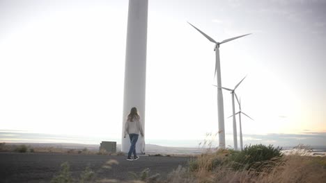 Model-walking-below-windmills-at-sunset-in-slow-motion