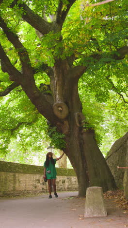 Vídeo-Vertical-De-Una-Turista-Con-Cámara-De-Vacaciones-En-Oxford,-Reino-Unido,-Explorando-Las-Calles-De-La-Ciudad-Caminando-Por-El-Paso-De-Lamb-Y-Flag-Tocando-Un-árbol-2