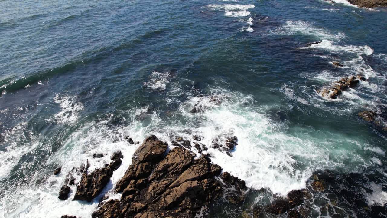 hermosas olas que se rompen en las rocas de un océano azul.