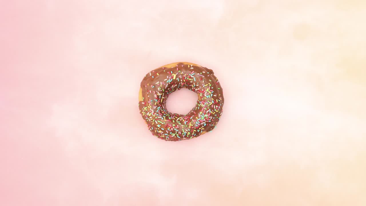 вкусные пончики с шоколадом меняются на розовом фоне - остановите движение
