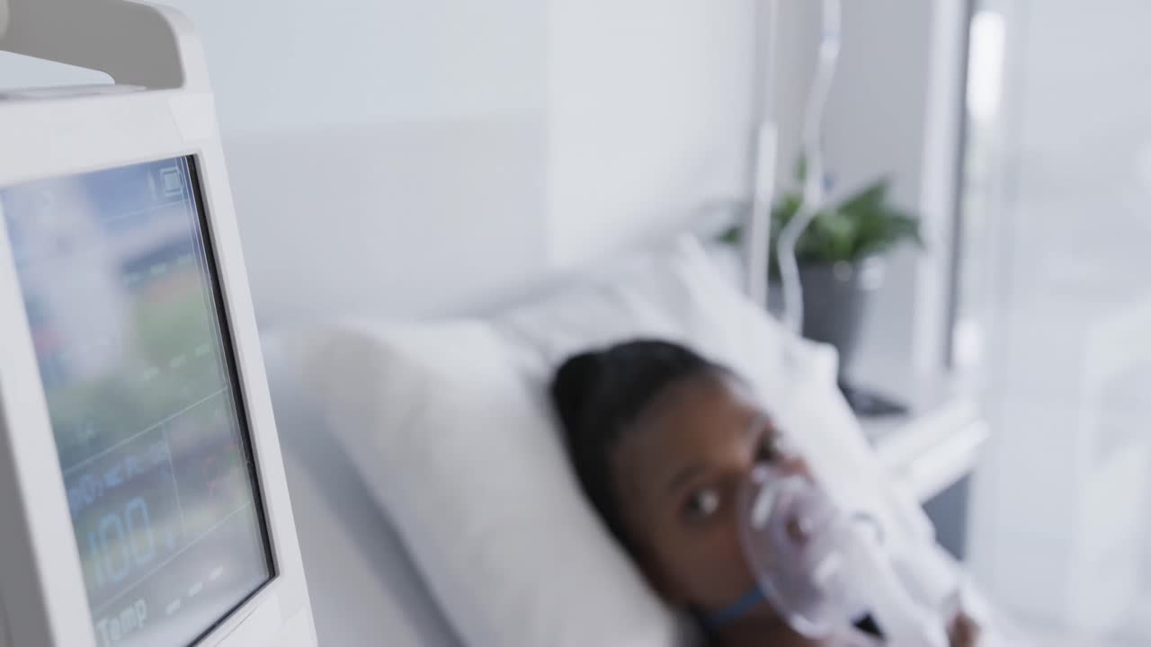 paciente afroamericana con máscara de oxígeno acostada en la cama en una habitación de hospital, cámara lenta