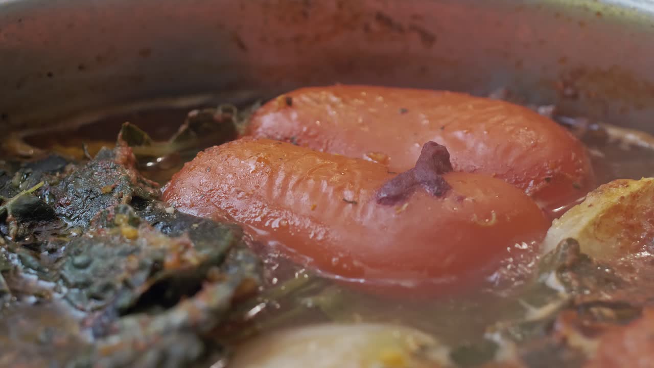 Red Pepper Boiling In A Delicious Vegetable Soup With Onions And Spices - Extreme Close Up