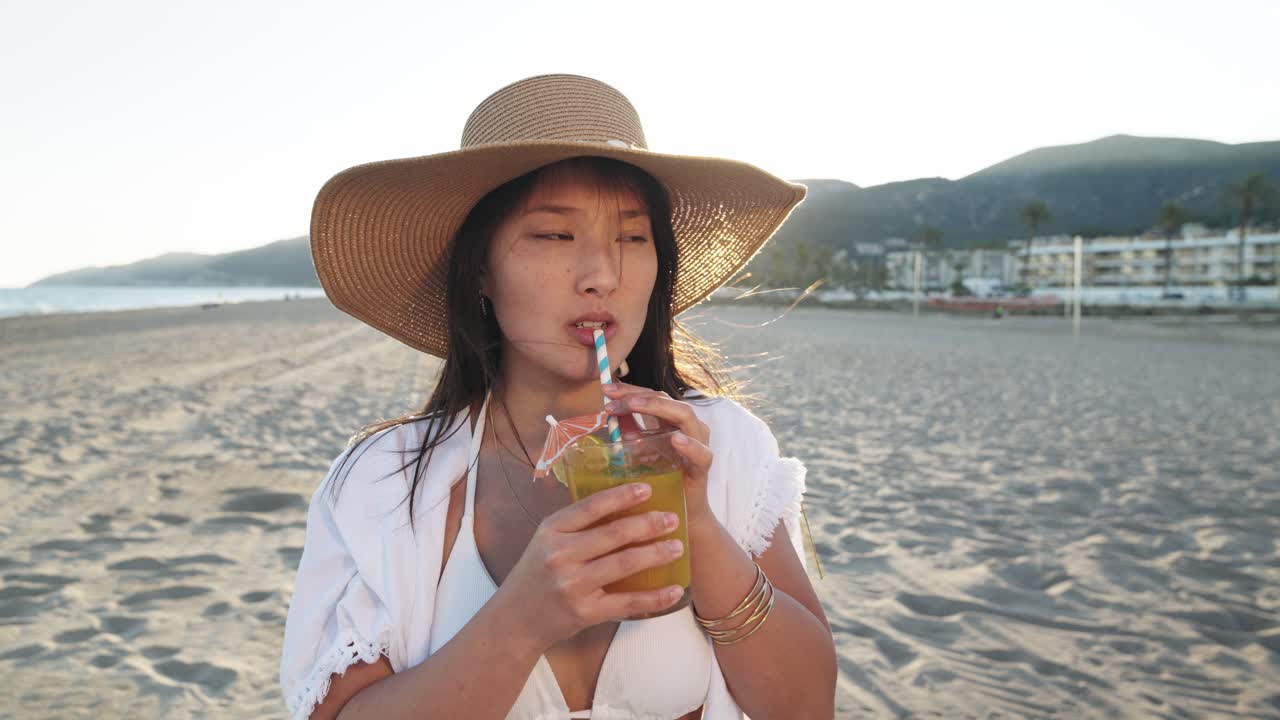 mujer disfrutando de un cóctel en la playa