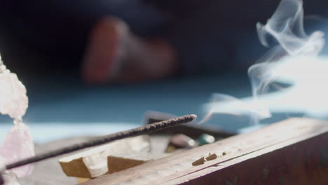 Burning-incense-sticks-in-holder-on-floor