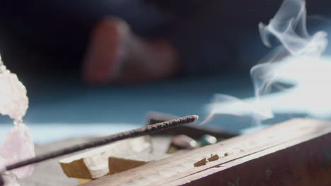 burning incense sticks in holder on floor