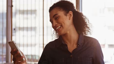 Smiling-woman-using-smartphone-while-having-coffee