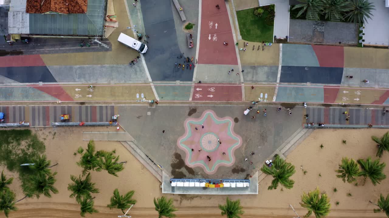 Rising bird's eye top view of the center plaza at the touristic Tambaú beach boardwalk in the tropical beach city of Joao Pessoa, Paraiba, Brazil with people gathering for pictures at the sign