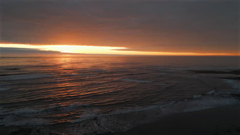 establishing aerial drone shot over sea at stunning sunrise in north yorkshire at low tide uk