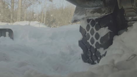 person struggling to get out of deep snow with a truck