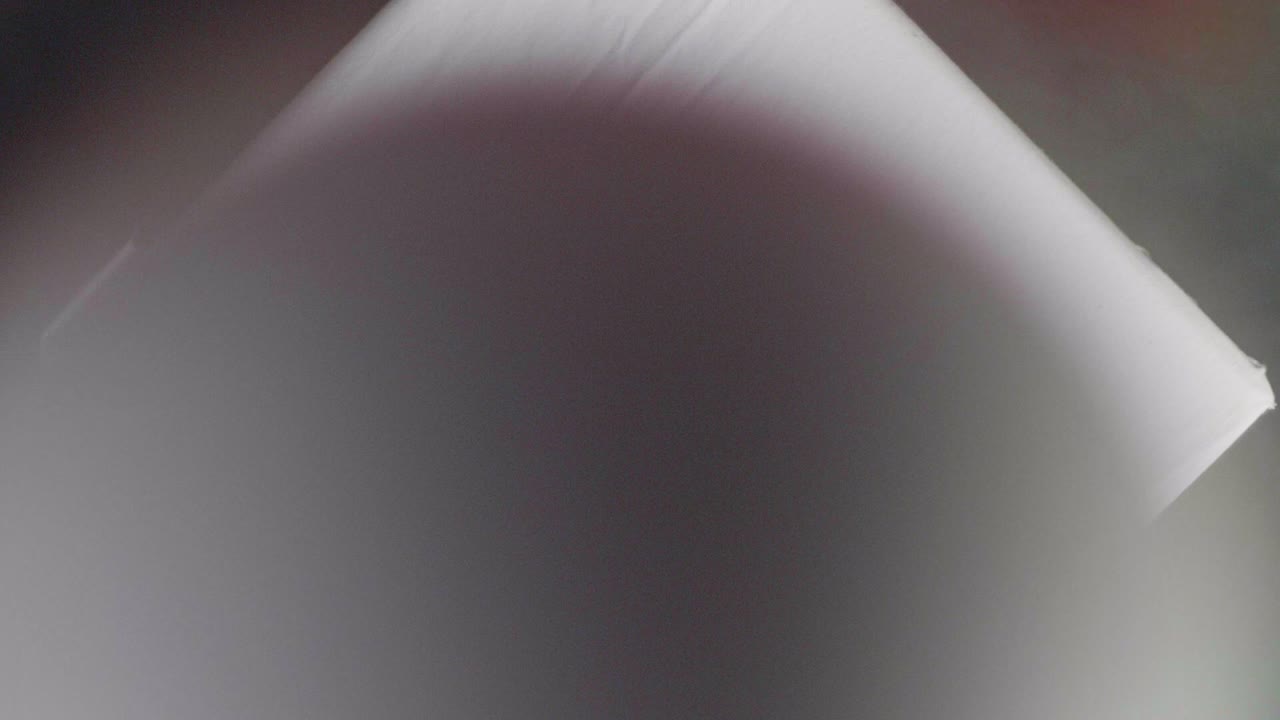 una esfera blanca cayendo sobre un pedestal blanco sobre un fondo gris