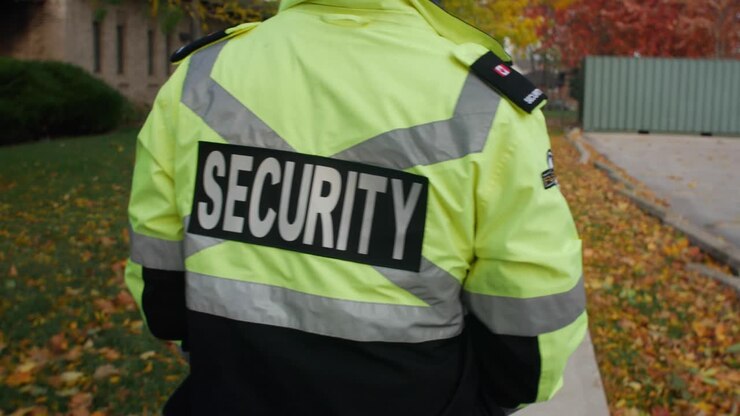 Addetto alla sicurezza in uniforme che pattuglia un'area commerciale.