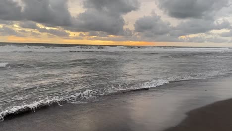 cloudy sky over crashing waves at seashore beach in indonesia during sunset