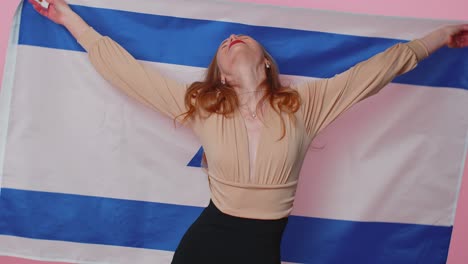 cheerful lovely teen girl waving and wrapping in israel national flag celebrating independence day