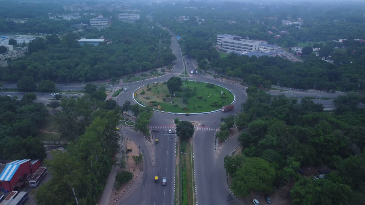 The Tribune Chowk roundabout surrounded with green trees, Tribune newspaper publisher office building in view, Chandigarh, Drone shot