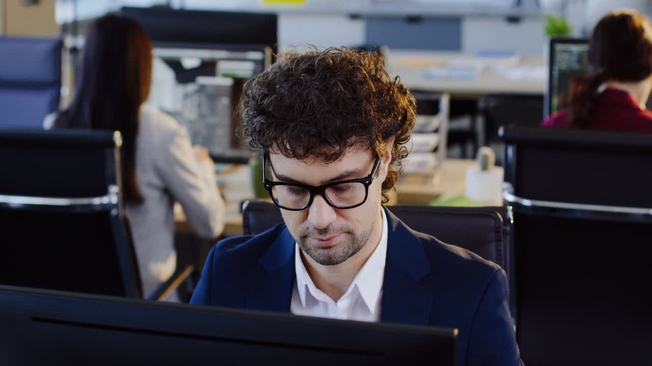 Caucasian businessman in glasses working on computer in the office