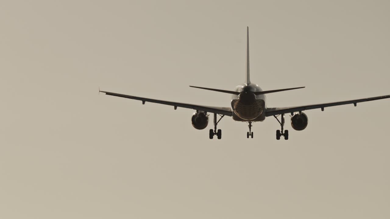 Avión volando en el cielo para aterrizar en el aeropuerto a cámara superlenta al atardecer