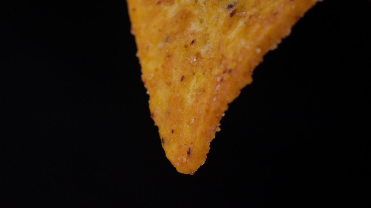 Slow motion macro shot of nachos seasoned with spices