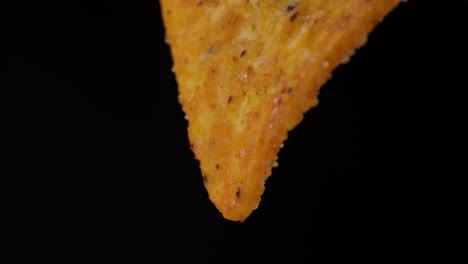 slow motion macro shot of nachos seasoned with spices