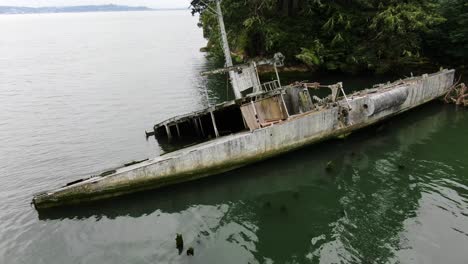 Aerial-orbit-above-old-shipwreck-of-USS-Plainview-boat-on-calm-overcast-day