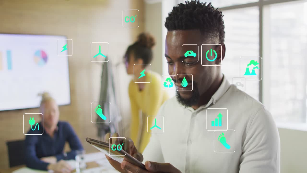 Animation of icons over african american businessman using tablet at office