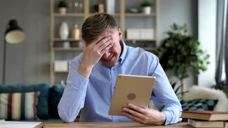 hombre de negocios reaccionando a la pérdida mientras usa la tableta