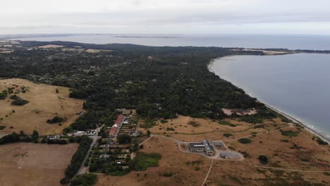 Aerial-view-of-the-coastline-of-Sejerøbugten-with-hills,-fields-and-ocean