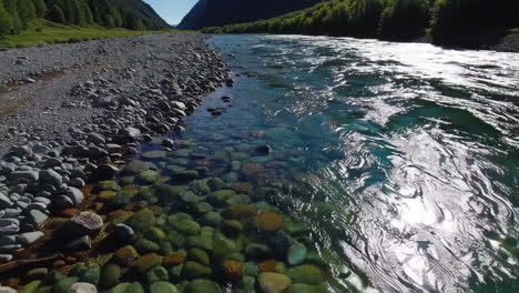 scenic river with rocky bank and mountain forest backdrop