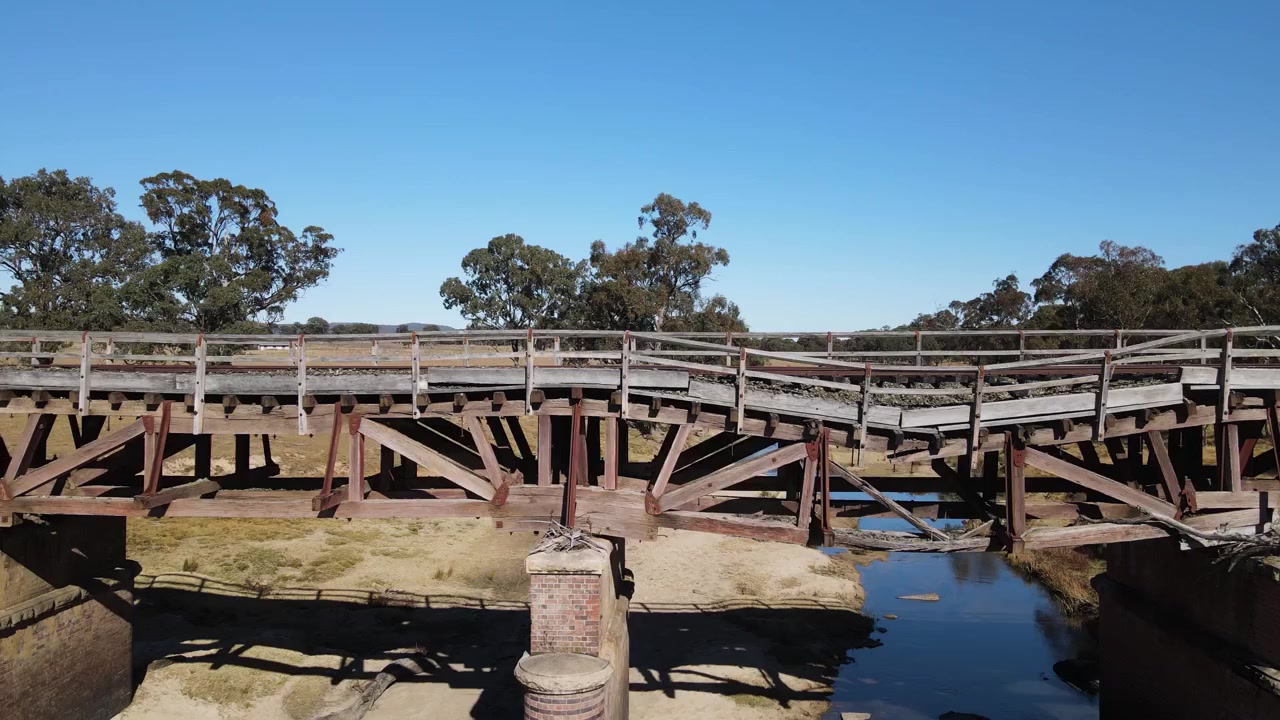 Vecchia linea ferroviaria rurale e ponte su un fiume dell'entroterra australiano danneggiati da una recente alluvione