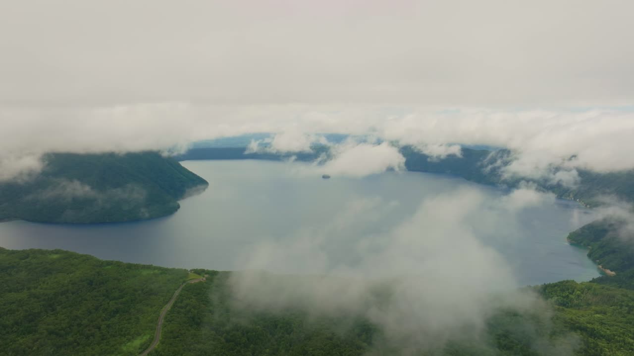 Aerial fly above clouds in Hokkaido Japan, Lake Mashu's Panoramic view, Japanese natural landscape, volcanic crater environment