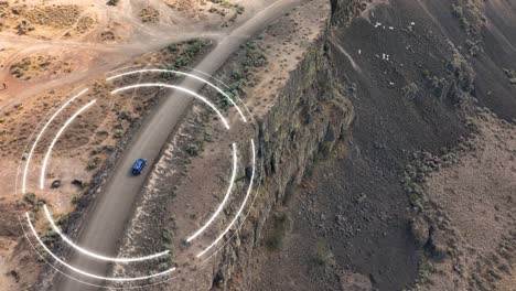 Drone-shot-of-a-self-driving-car-using-its-sensors-to-navigate-a-cliffside-in-the-desert