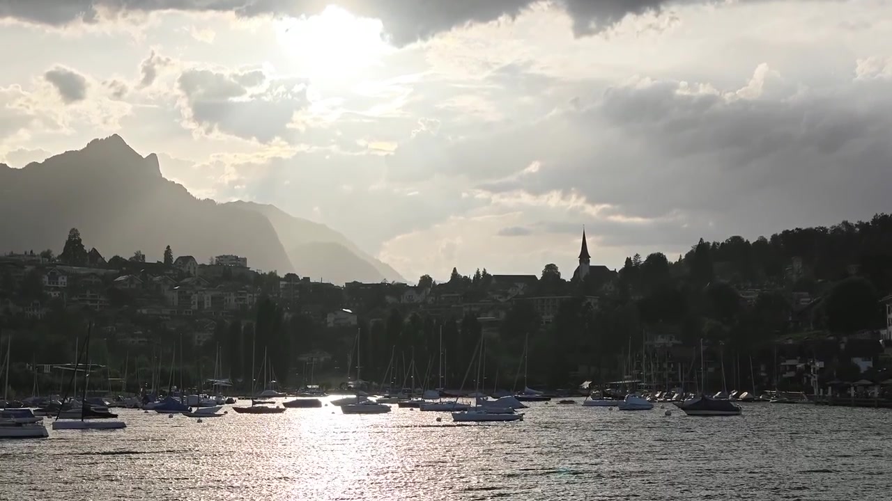 Splendida crociera al tramonto sul Lago di Thun in avvicinamento a Spiez, Svizzera. Una popolare fermata del traghetto famosa per il suo castello medievale, chiesa, ristoranti, vigneti e caffè