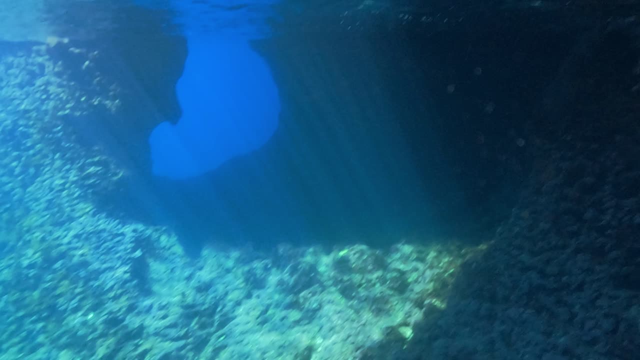increíble paisaje de cuevas de piedra caliza bajo el agua con agua de mar azul profundo y rayos de luz