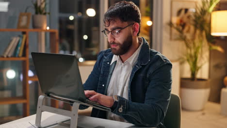 man working on laptop at night