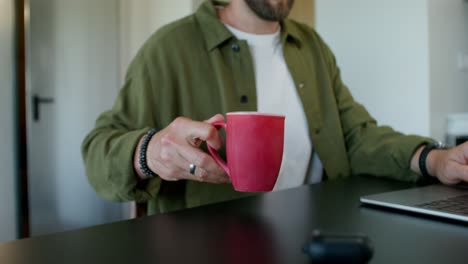 man working from home, drinking coffee