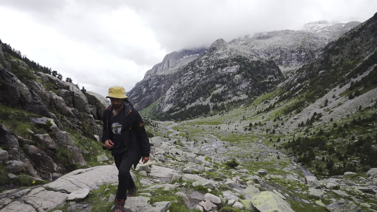 male reaching top of uphill mountains path in Aig&uuml;estortes National Park in the Catalan Pyrenees Spain