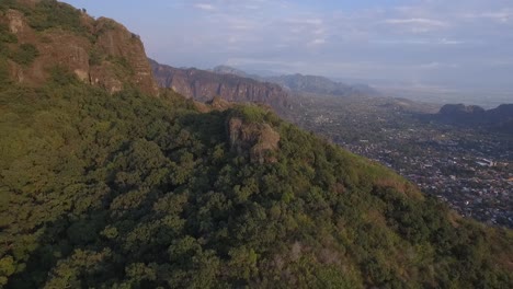 aerial revealing shot of the vast forestry in the mexican countryside with a village