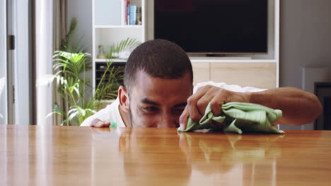 a young handsome man cleaning the countertop