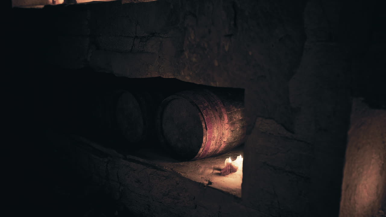 Old cellar with wine barrels and candles creating a mysterious ambiance