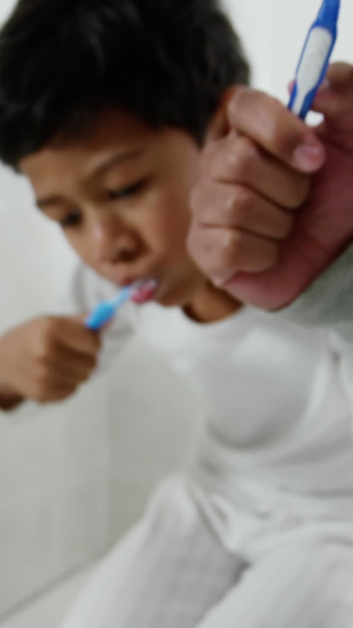 Father and son brushing teeth in the bathroom