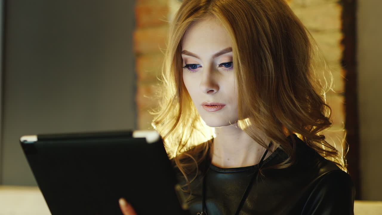 женщина модель на вид 20-25 лет сидит в кафе работает с планшетом волосы красиво подсвечены