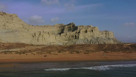 aerial over arabian sea and beach with rugged mountains of hingol national park in background