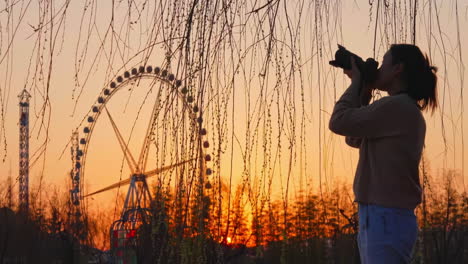 Echte-Aufnahme-Einer-Silhouette-Eines-Jungen-Fotografen,-Der-Mit-Einer-Professionellen-Kamera-In-Der-Farbe-Eines-Goldenen-Sommerhimmels-Bei-Sonnenuntergang-Fotografiert