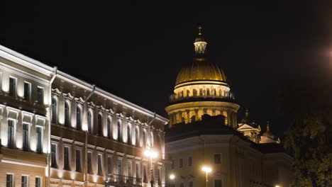 night view of a european city with illuminated buildings and a cathedral